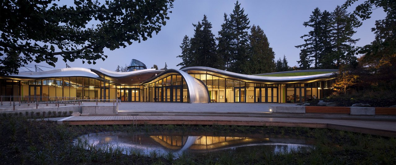 VanDusen Visitor Centre 花瓣形屋顶全景，六个起伏曲面从中心 oculus 向外展开，从 Oak Street 入口方向拍摄