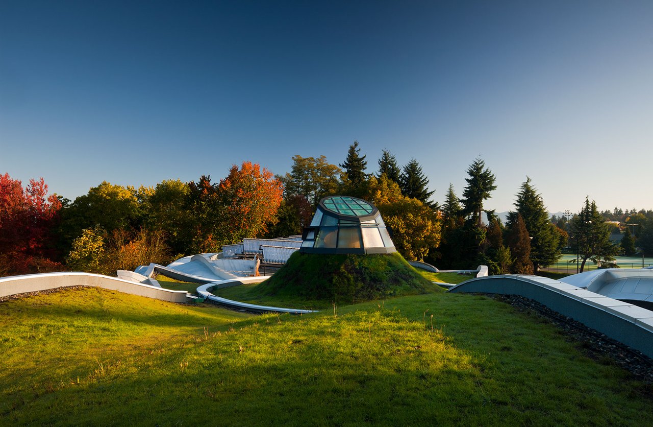 VanDusen Visitor Centre 中心 oculus 与太阳能烟囱，圆形开口上方设有可开合玻璃顶盖和铝制散热翼片
