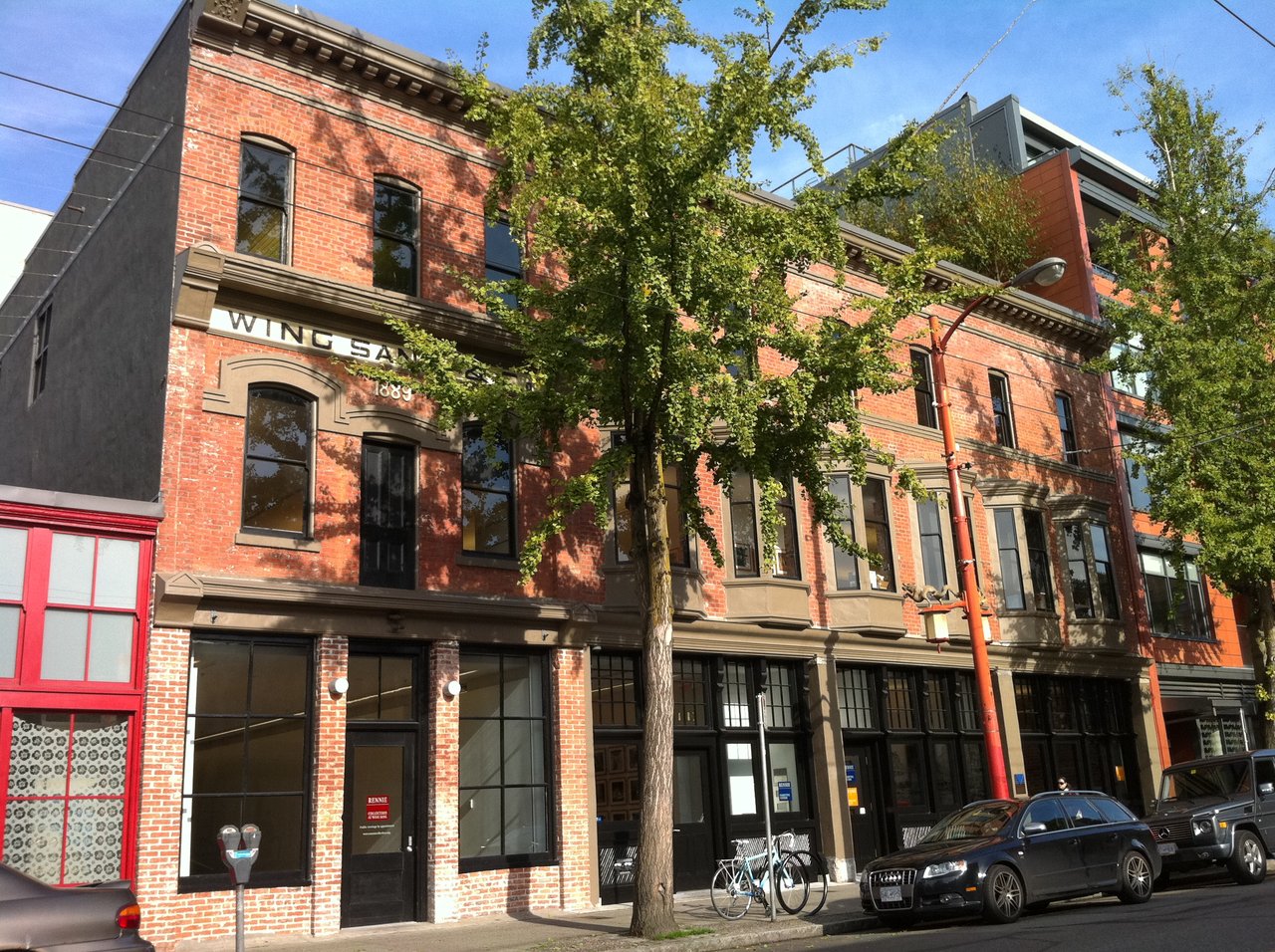 Wing Sang Building 南立面，三段砖色差标记 1889 初始段、1901 加盖段和 1912 加建段的施工顺序