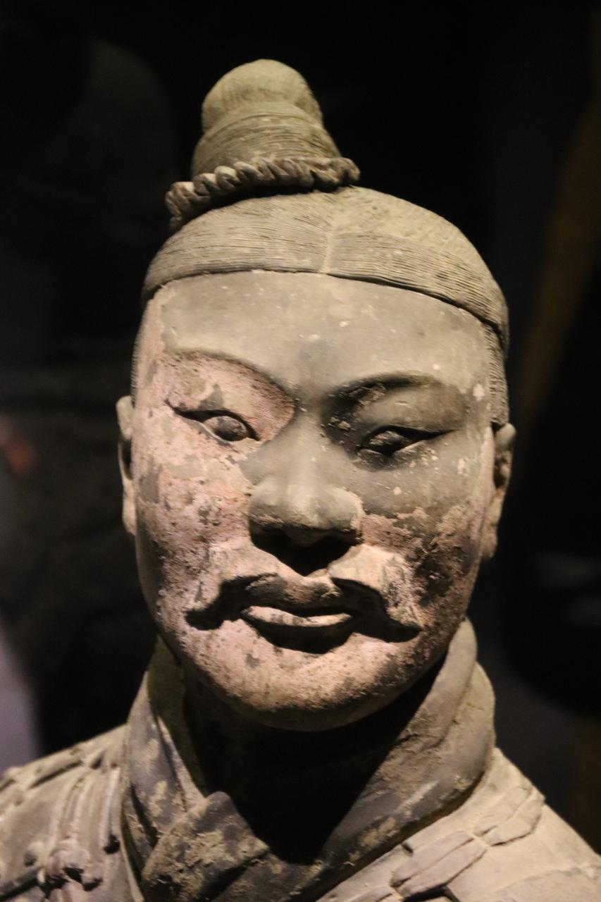 跪射俑侧面特写：铠甲纹理与鞋底编织纹路清晰可见，工艺精度极高