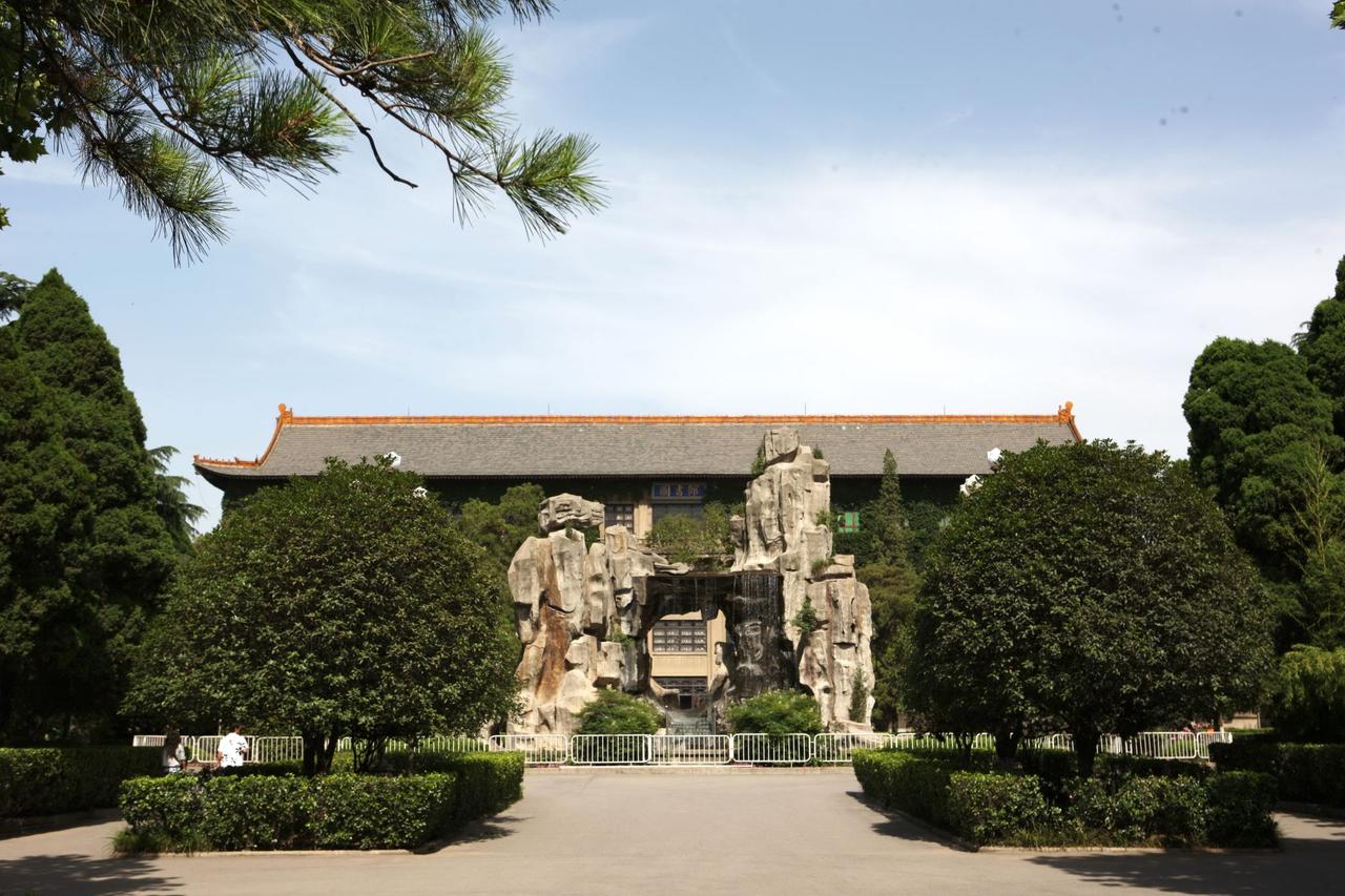 陕西师范大学雁塔校区图书馆正面，歇山式大屋顶与门前雪松