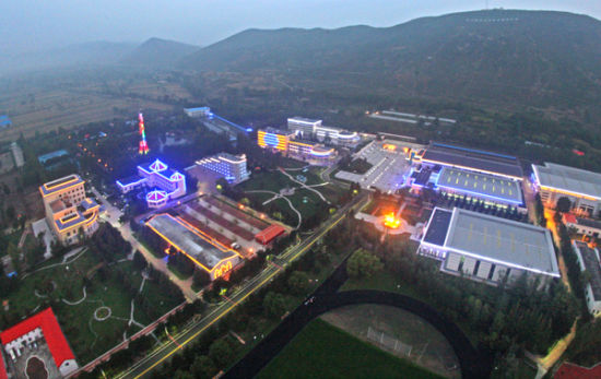 多巴基地夜间全貌：亮灯的体育场馆群镶嵌在河谷与山体之间