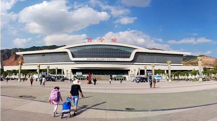 西宁站现代化的站房建筑，白色钢结构与玻璃幕墙构成高原之门的设计意象。