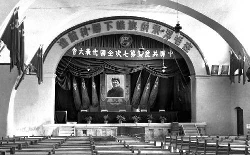 杨家岭中央大礼堂内部：主席台、环形标语和密集排列的座位，七大会场保持原状陈列