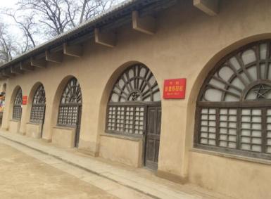 边区银行右侧面，建筑直接贴在崖壁上，展示了前楼后窑的混合结构