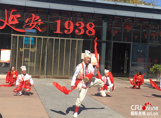 安塞腰鼓表演者在延安1938街区广场上演出,背景建筑可见"延安 1938"字样