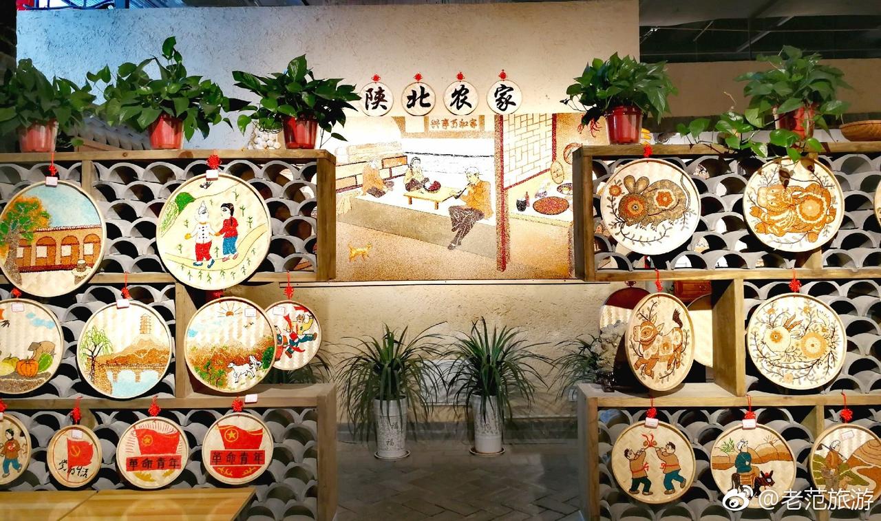 延安1938街区餐饮区内部,墙上装饰有陕北农家和革命主题壁画