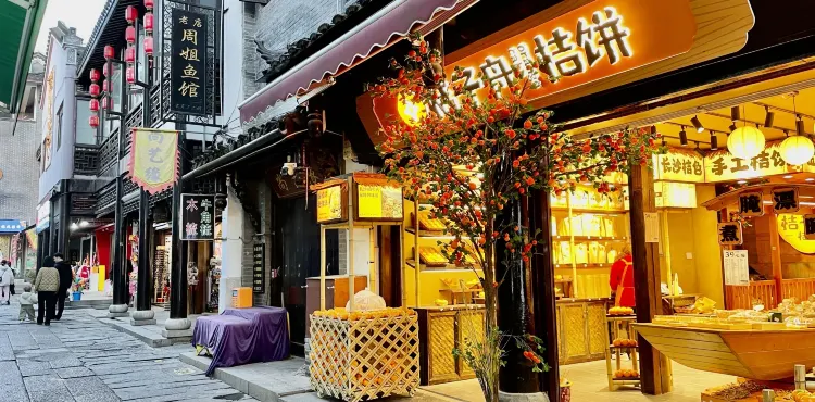 汴河街商业街景,两侧仿古店铺沿街排开,游客穿行其间