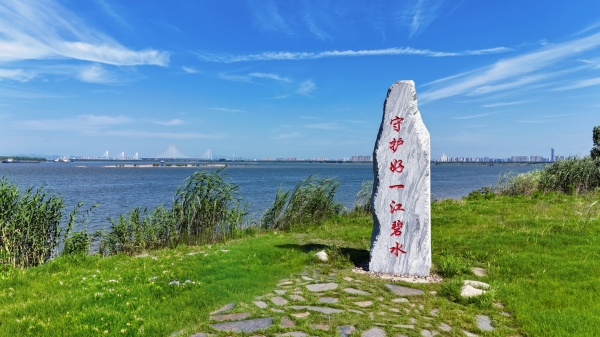君山区沿湖大堤，新修混凝土堤防高大厚实，堤外可见旧堤痕迹和恢复中的湿地