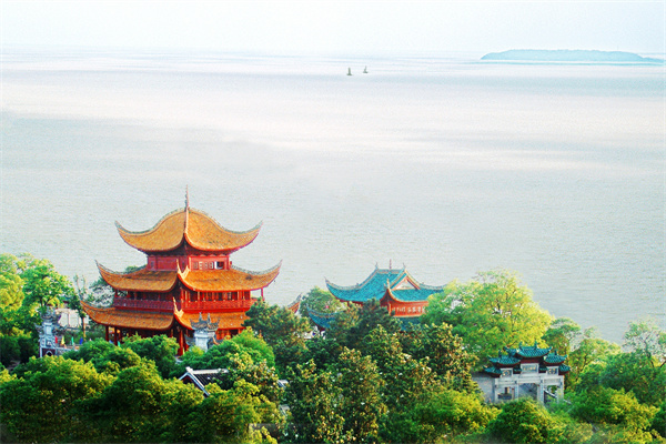 岳阳楼侧影,黄色琉璃瓦的盔顶轮廓在洞庭湖背景下清晰可见