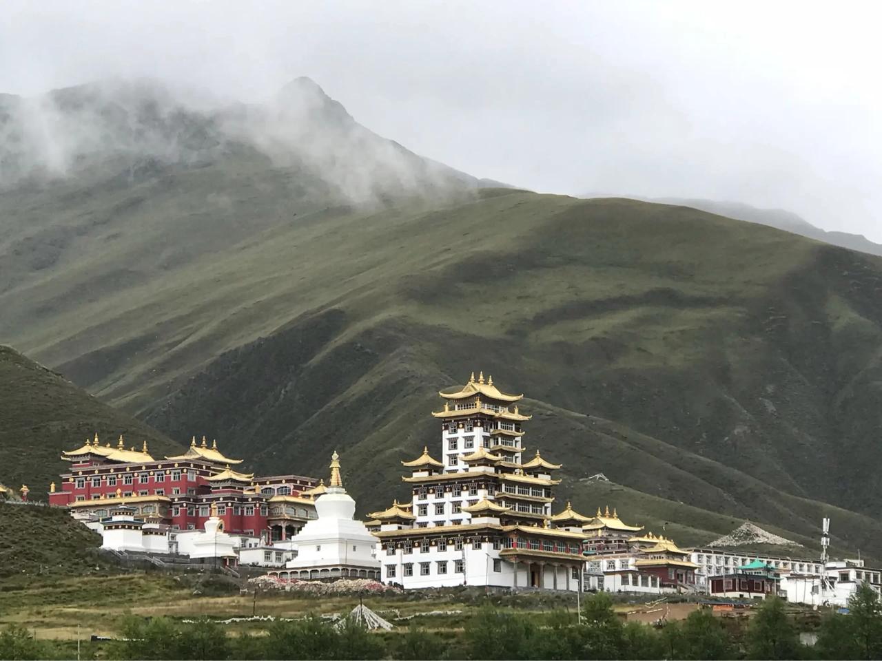 新旧经堂对比：左侧旧经堂与外露的混凝土新建筑