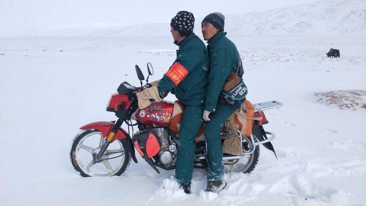 生态管护员骑着摩托车在雪地中巡护
