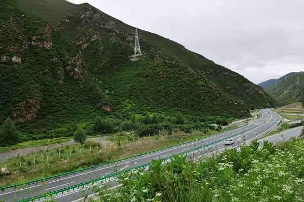 共玉高速在冻土区蜿蜒穿行,路面上方是青藏高原的起伏山峦