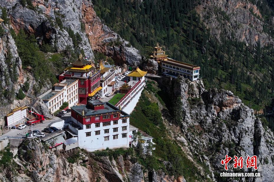 尕尔寺远景：红白色建筑群嵌在灰黑色崖壁上