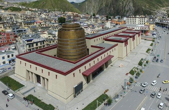 玉树州博物馆外观，土黄色主体配绛红檐口，正面金铜色柱形展厅