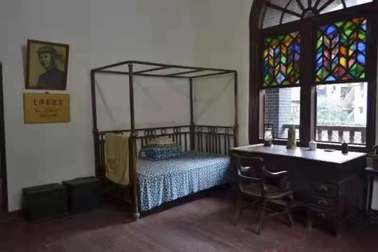 毛泽东住室复原陈设，铜床与红漆九抽桌，彩色玻璃窗为建筑典型特征