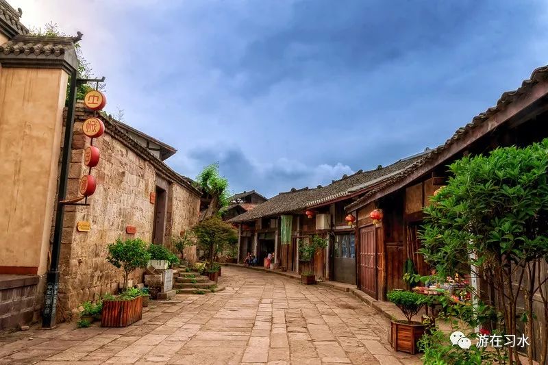 土城古镇石板老街，两侧建筑保留前店后宅格局，可见传统旗幡与店铺